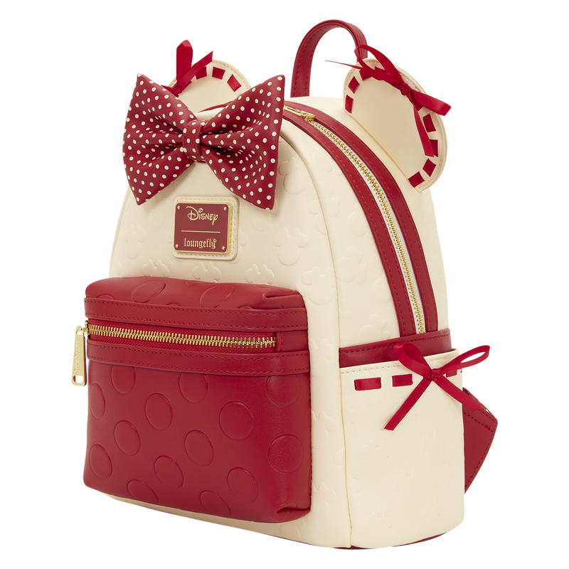 Backpack with red and white polka dot bow, gold zippers, and Disney logo on a white background