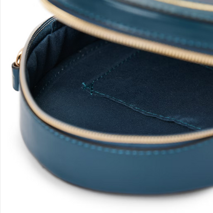 Close-up of a blue round pouch with a gold zipper on a white background