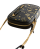 Black handbag with gold chain strap and detailed design on a light gray background