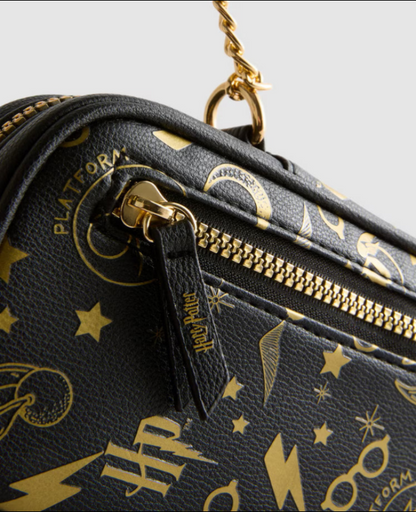 Black handbag with gold Harry Potter-themed patterns on a light gray background