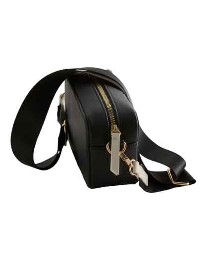 Black crossbody bag with a gold zipper on a light gray background