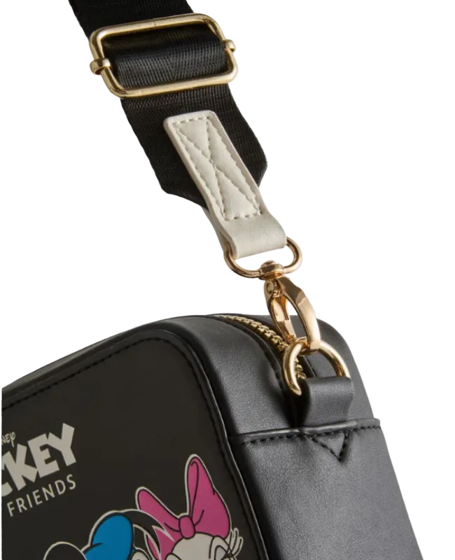 Black bag with gold zipper and strap, featuring a character design on a light gray background