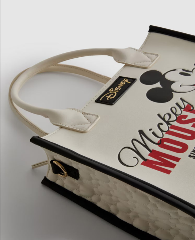 Beige tote bag with 'Mickey Mouse' text and Disney logo on a light gray background