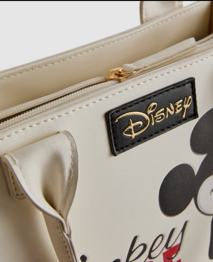 Beige handbag with Disney logo and Mickey Mouse design on a white background