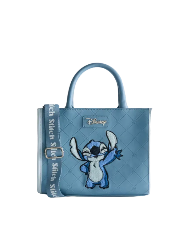 Blue quilted handbag with a character design on a light gray background