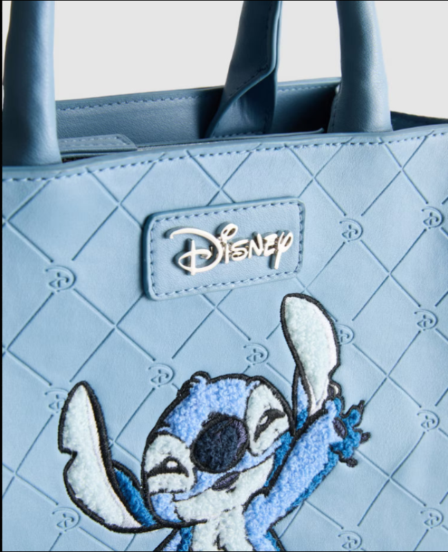 Light blue quilted handbag with a Disney logo and embroidered character on a light gray background