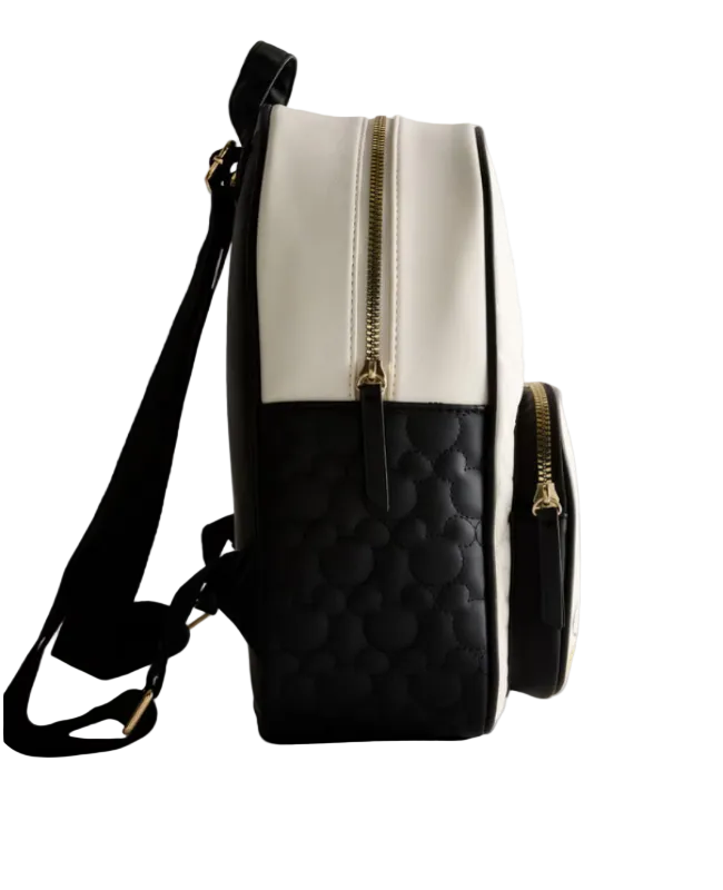 Black and white quilted backpack with gold zipper on a light gray background