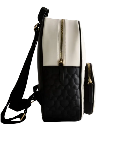 Black and white quilted backpack with gold zipper on a light gray background