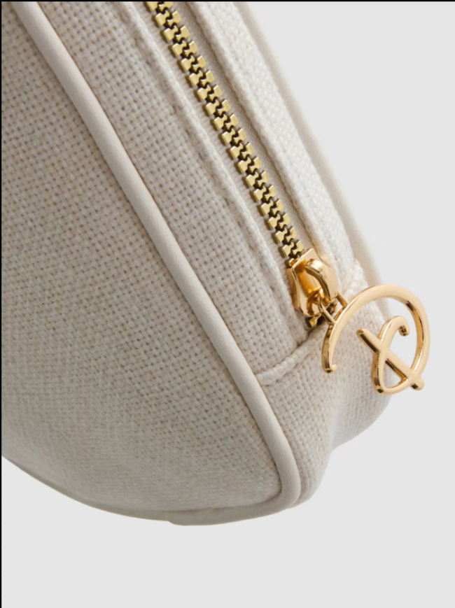 Beige handbag with gold zipper and logo on a light gray background