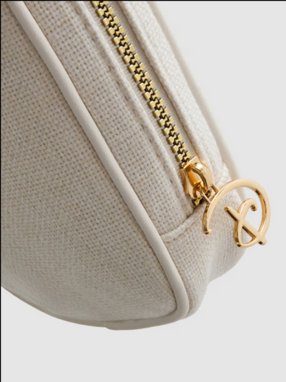 Beige handbag with gold zipper and logo on a light gray background