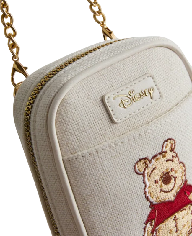 White pouch with embroidered bear design and Disney logo on a light gray background