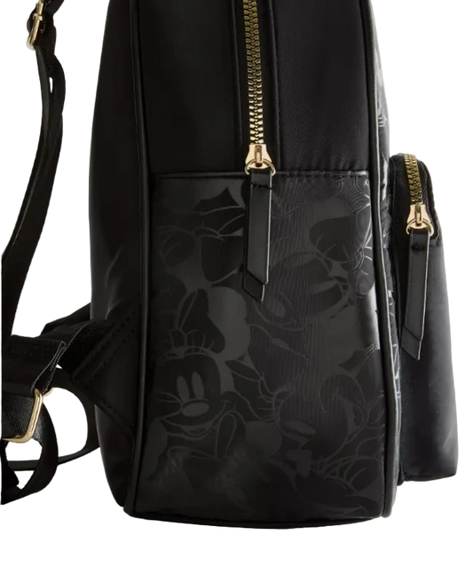Black backpack with floral pattern and gold zippers on a light gray background