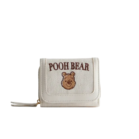 Small beige wallet with 'POOH BEAR' embroidery on a light gray background