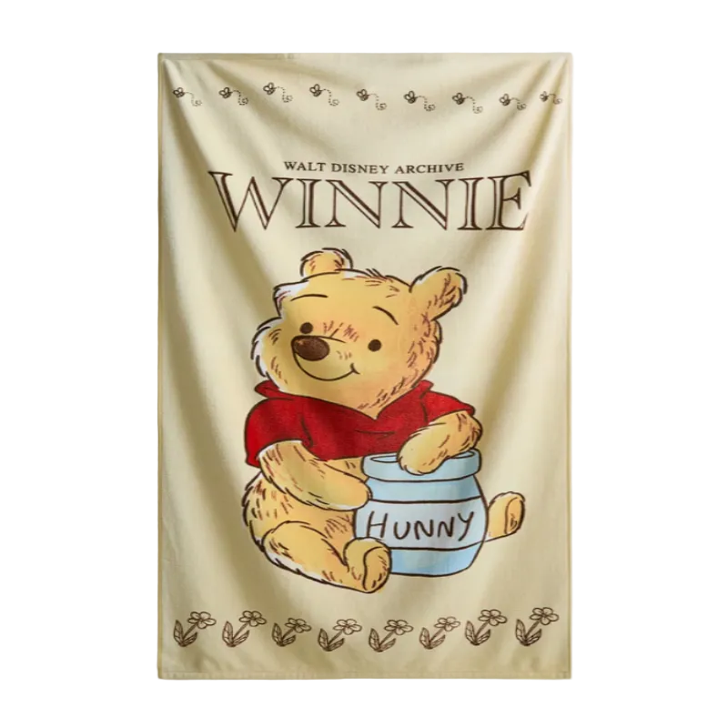 Winnie the Pooh towel with a jar of honey on a beige background