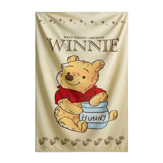 Winnie the Pooh towel with a jar of honey on a beige background