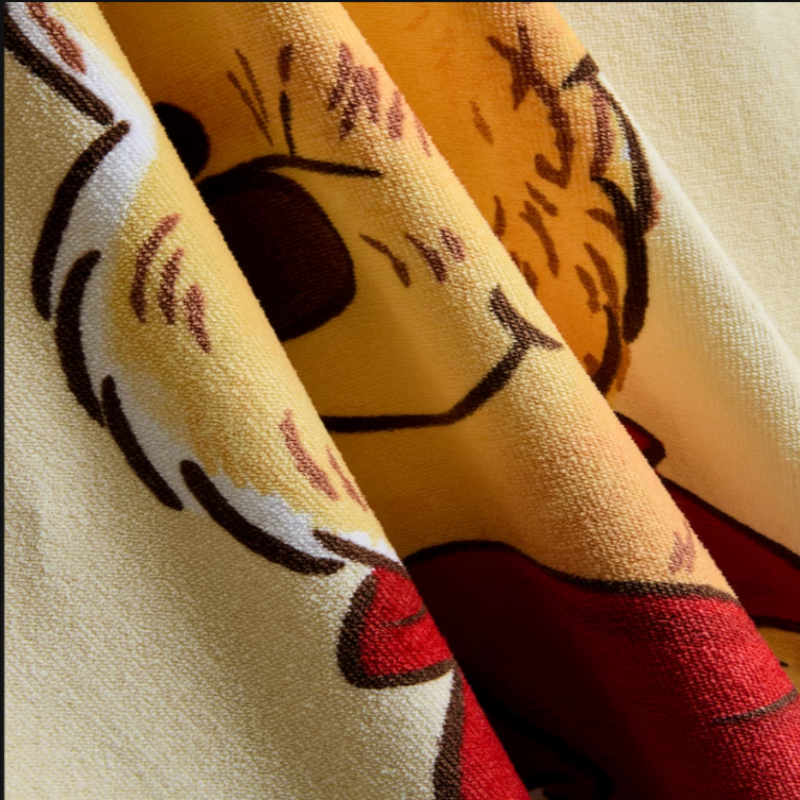 Close-up of a fabric with a pattern resembling a face on a yellow background
