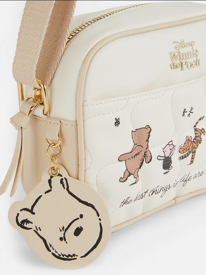White crossbody bag with Winnie the Pooh design and character illustrations on a white background
