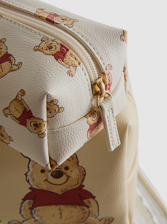 Close-up of a cream-colored pouch with bear illustrations on a matching background