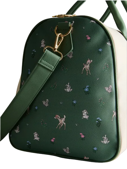 Green handbag with embroidered designs on a light gray background