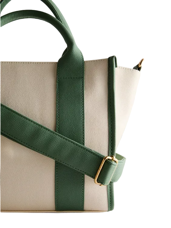 Beige handbag with green straps on a light gray background