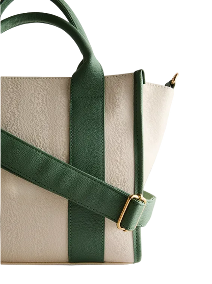 Beige handbag with green straps on a light gray background