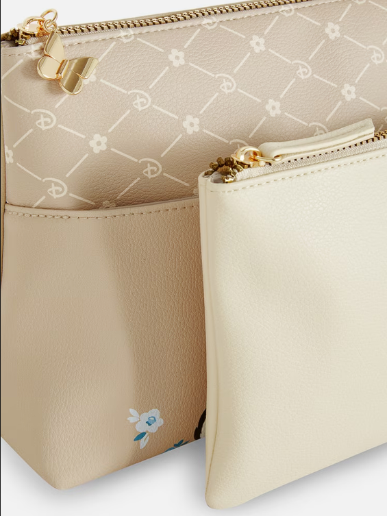 Beige handbag with floral design and gold zipper on a light background