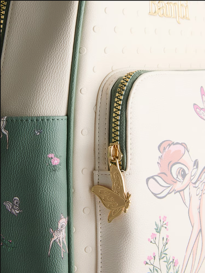 Close-up of a green and white bag with floral patterns and a gold zipper pull.