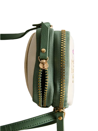 Green crossbody bag with gold zipper on a light gray background