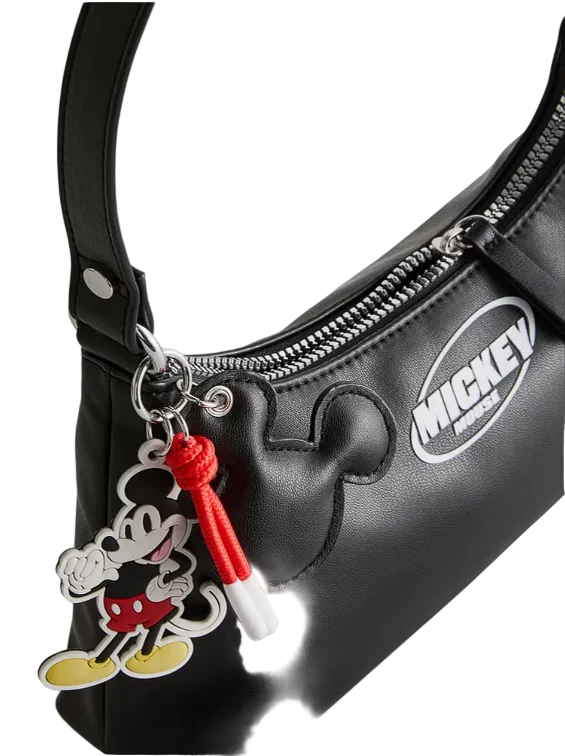 Black handbag with a Mickey Mouse charm on a white background