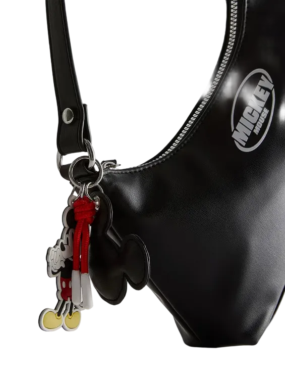 Black handbag with a Mickey Mouse keychain on a white background