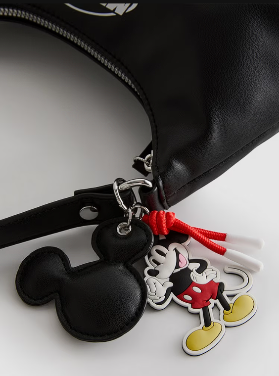 Mickey Mouse keychain attached to a black bag on a white background