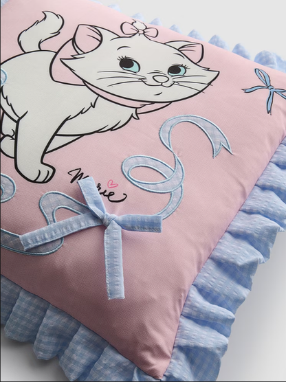 Decorative pillow with a cartoon cat design on a pink background