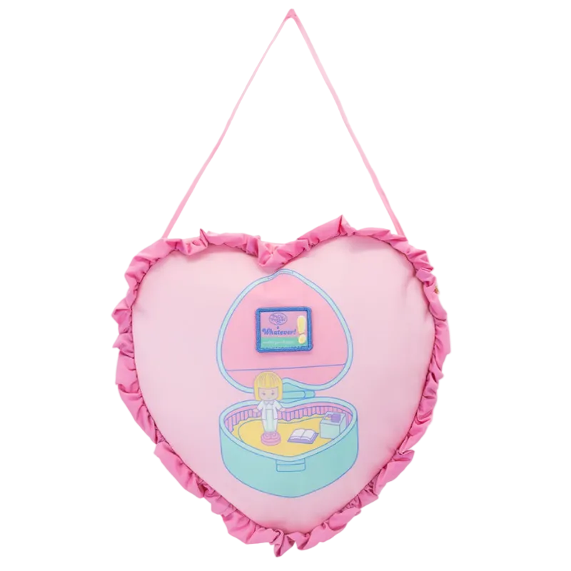 Heart-shaped pink pillow with a toy inside on a white background