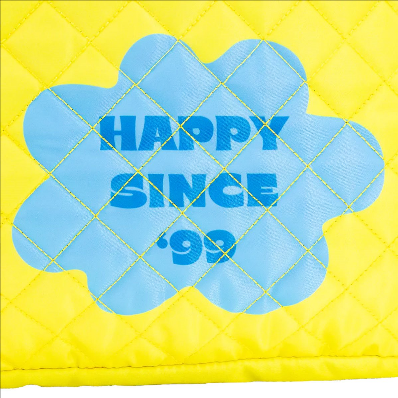 Yellow quilted pillow with blue floral design and 'Happy Since '99' text