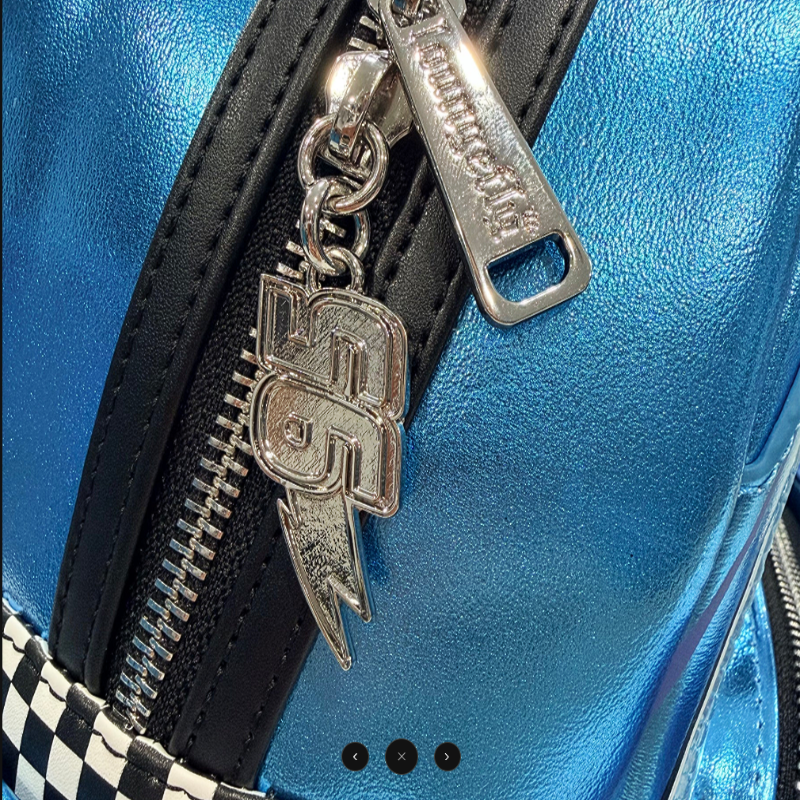 Close-up of a blue leather bag with a silver zipper pull and emblem.