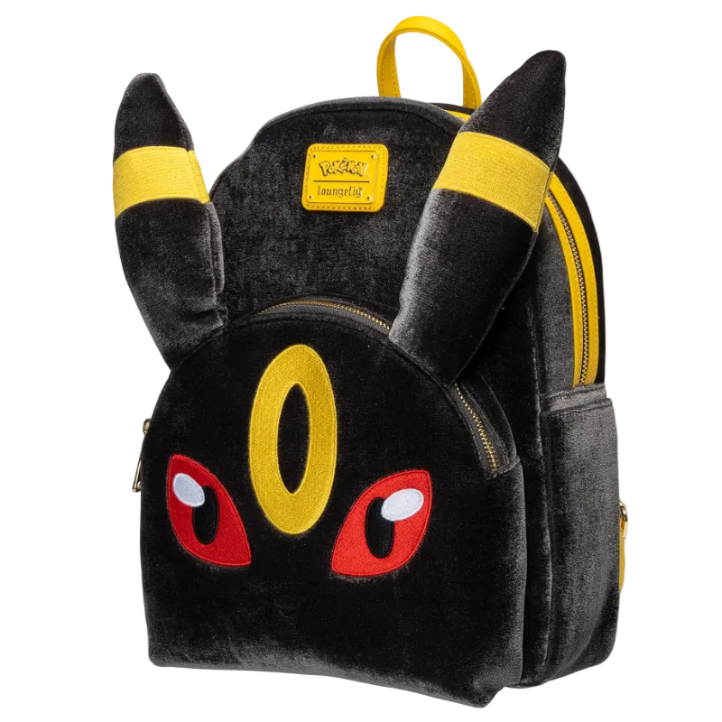 A black plush Pikachu-themed backpack with yellow ear bands, a yellow eye detail, red embroidered eyes, and gold zippers, shown on a plain white background.