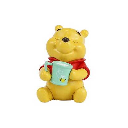 Yellow bear character holding a green mug with a straw on a white background