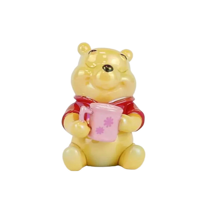 A small Winnie the Pooh bear figurine holding a pink mug with pink flower details, set against a plain white background.