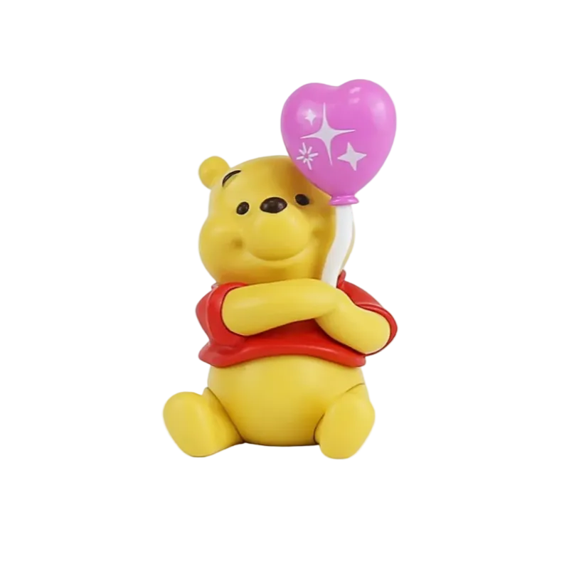 A small Winnie the Pooh bear figurine holding a pink heart-shaped balloon with white star details, wearing a red shirt, on a plain white background.