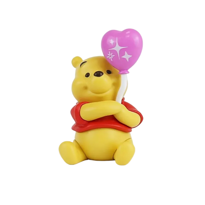 A small Winnie the Pooh bear figurine holding a pink heart-shaped balloon with white star details, wearing a red shirt, on a plain white background.