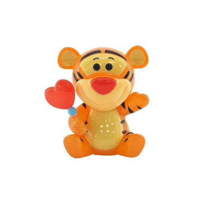Toy figure of a tiger holding a heart on a white background