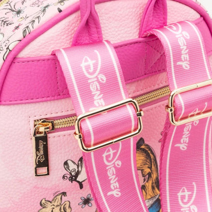 Close-up of a pink Disney backpack featuring printed character artwork, gold-tone zippers, and wide pink Disney shoulder straps with white logo text.