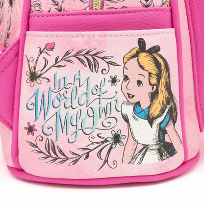 A close-up of a pink Disney-themed bag featuring a front pocket with a printed Alice in Wonderland design, including the text 'In a World of My Own' and an illustration of Alice with blonde hair and a blue dress.