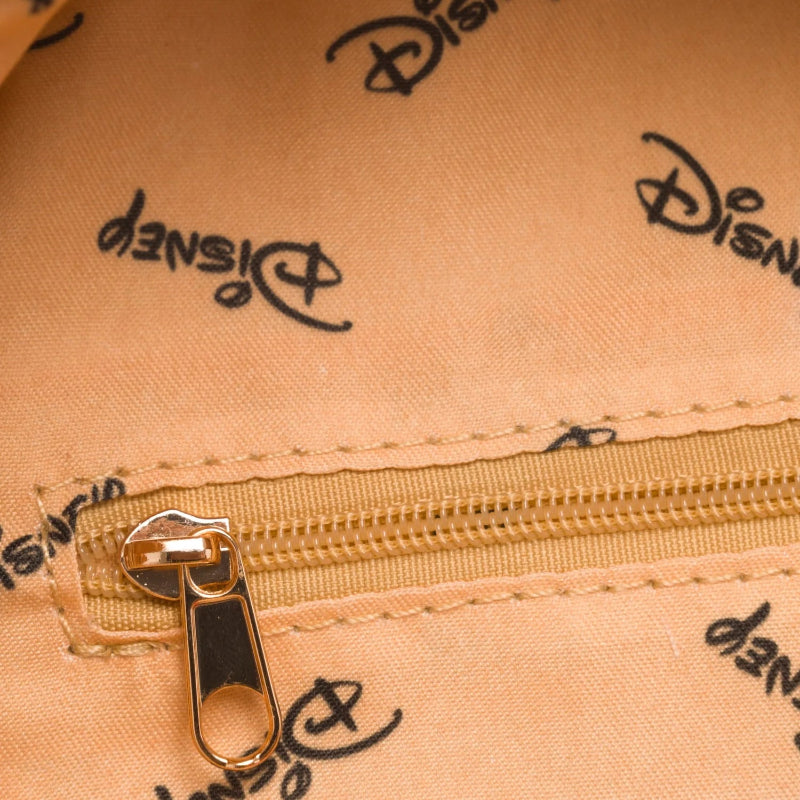 Close-up of a beige fabric with Disney logo pattern and gold zipper.