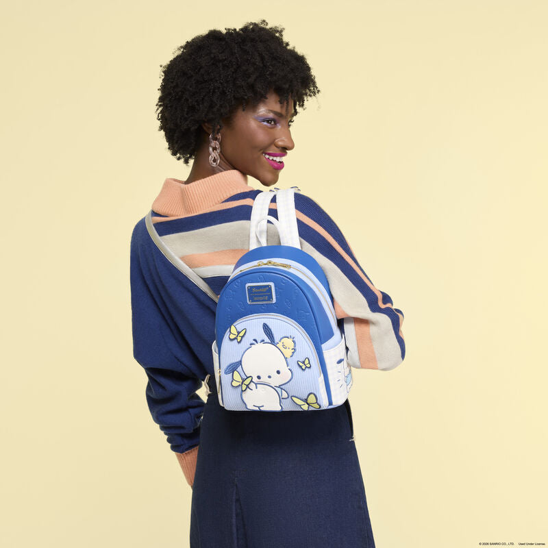 Woman wearing a blue backpack with cartoon character design on a beige background