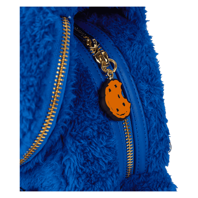 Blue fuzzy jacket with a gold zipper and orange pumpkin charm on a white background