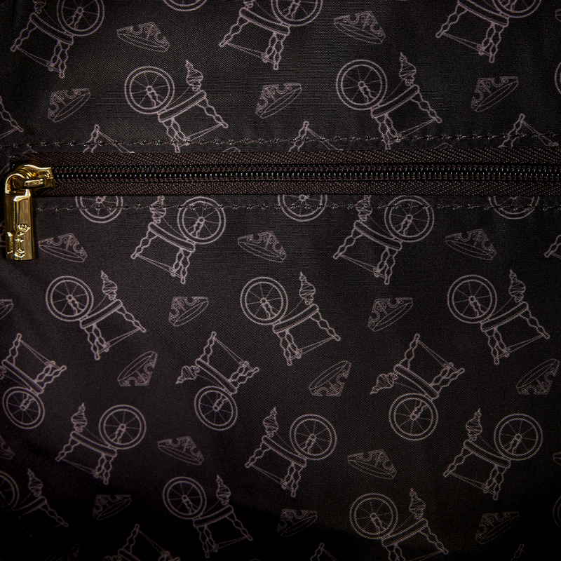 Close-up of a black bag with white pattern of people on unicycles, gold zipper pull visible.