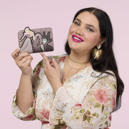 Woman holding a decorative wallet against a pink background