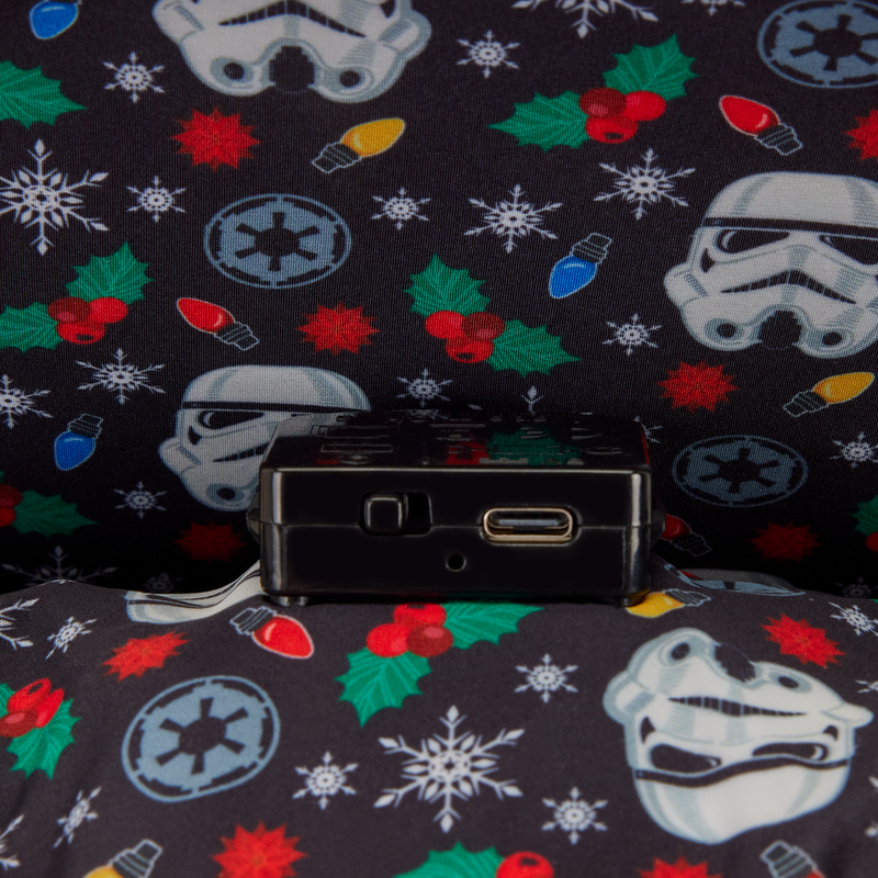 Black electronic device on a Star Wars-themed fabric background with stormtrooper helmets, lightsabers, and Christmas elements.