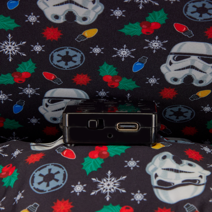 Black electronic device on a Star Wars-themed fabric background with stormtrooper helmets, lightsabers, and Christmas elements.